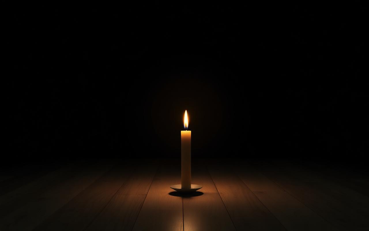 A single candle flame burning in a vast dark room with soft golden glow casting a small pool of light A single candle flame burning in a vast dark room with soft golden glow casting a small pool of light